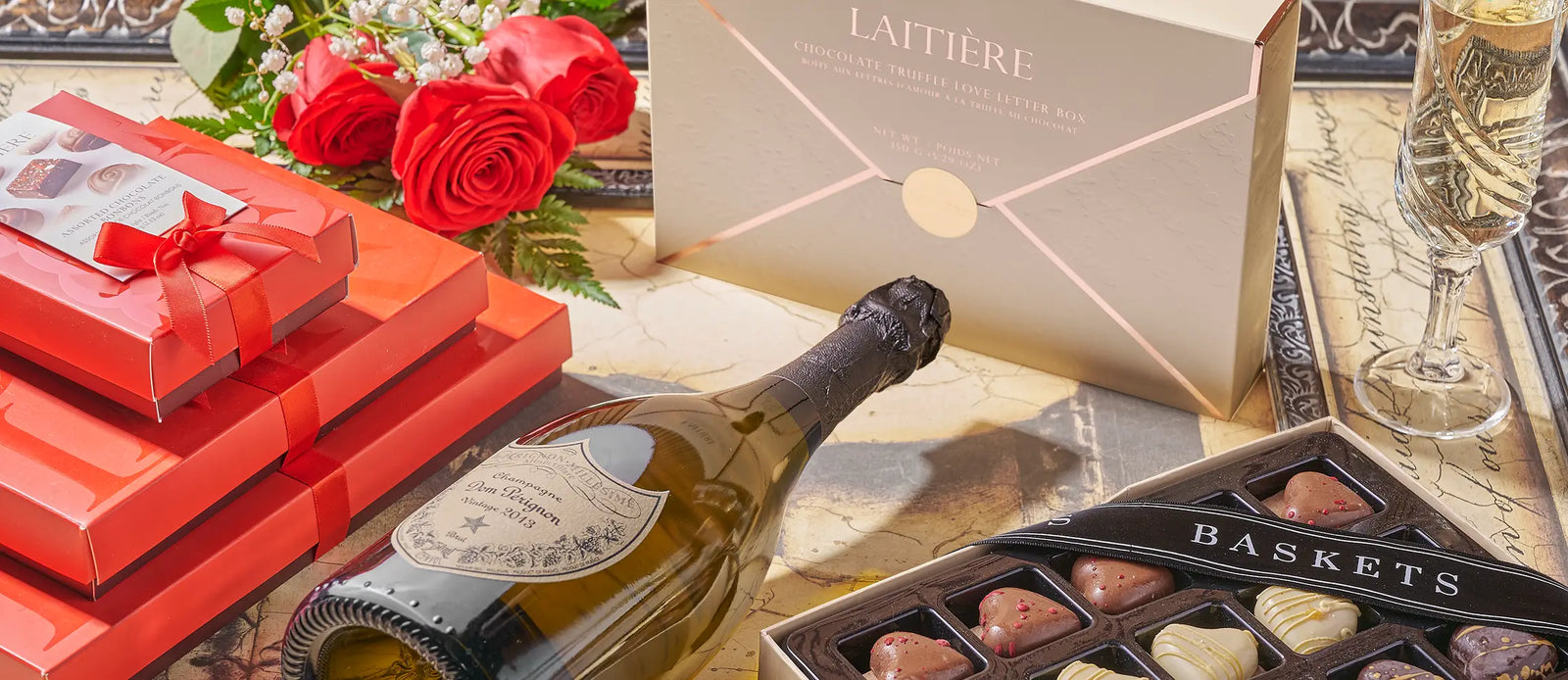 Champagne, roses, chocolates, and gift boxes arranged for a thoughtful Rhode Island gift basket delivery.