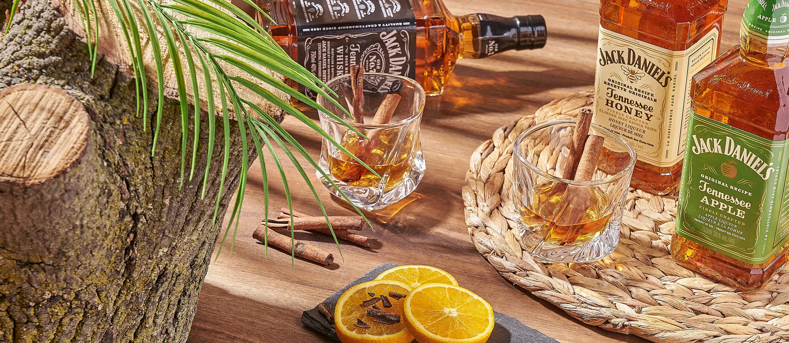 Whiskey bottles, cocktail glasses, cinnamon sticks, and orange slices arranged for a thoughtful Rhode Island gift delivery.